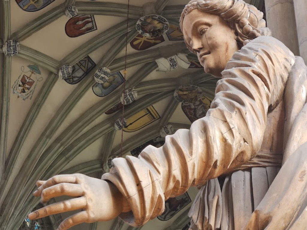 A statue of Saint Barbara inside St. Barbara Church. Coat of Arms on the ceiling show the medieval guilds of the city.